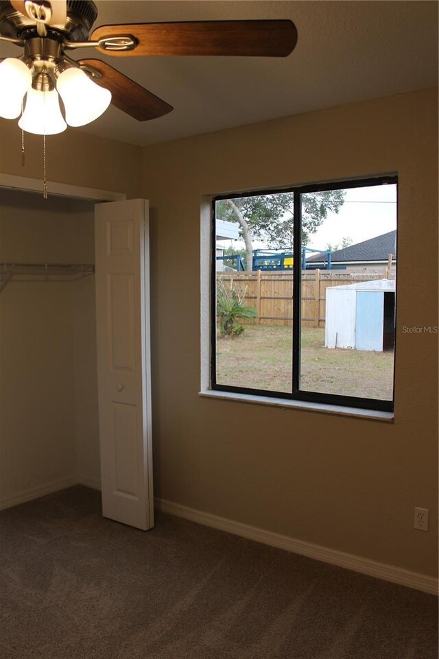 unfurnished bedroom featuring carpet, baseboards, a closet, and ceiling fan
