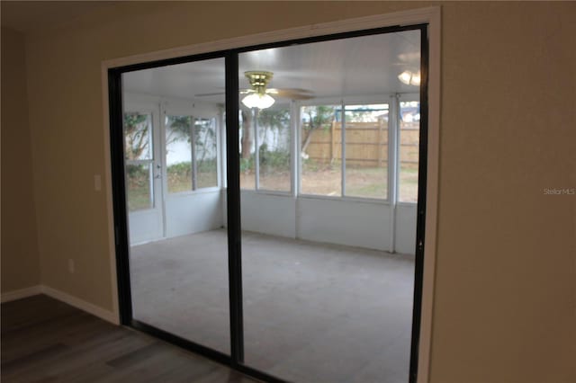 doorway to outside featuring ceiling fan, wood finished floors, and baseboards