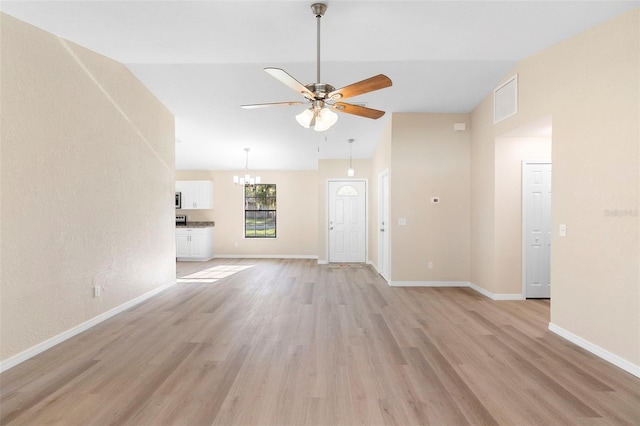 1550 Maxwell Ln, Deltona, FL 32738 - unfurnished living room featuring ceiling fan, light wood-style floors, a chandelier, vaulted ceiling, and baseboards