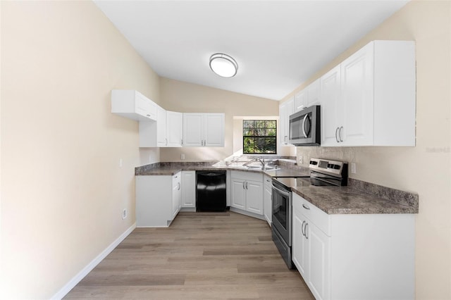 1550 Maxwell Ln, Deltona, FL 32738 - kitchen featuring appliances with stainless steel finishes, vaulted ceiling, a sink, white cabinets, and dark countertops