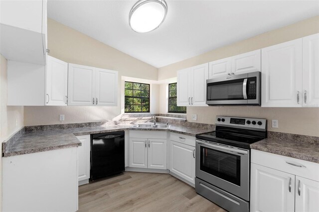 1550 Maxwell Ln, Deltona, FL 32738 - kitchen featuring stainless steel appliances, lofted ceiling, light wood-type flooring, white cabinets, and a sink