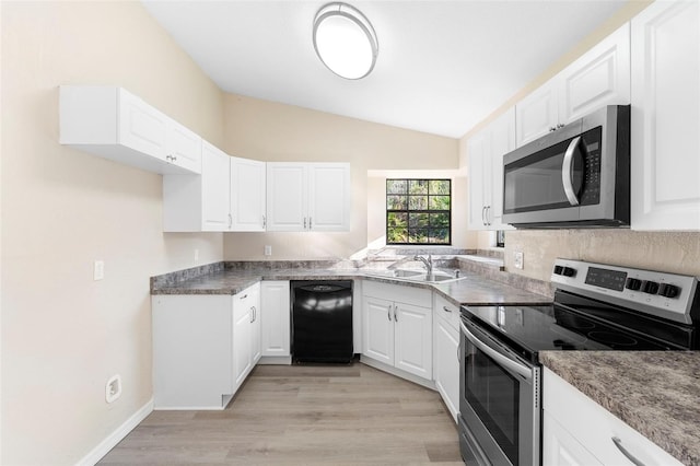 1550 Maxwell Ln, Deltona, FL 32738 - kitchen with stainless steel appliances, a sink, lofted ceiling, light wood-style floors, and white cabinetry