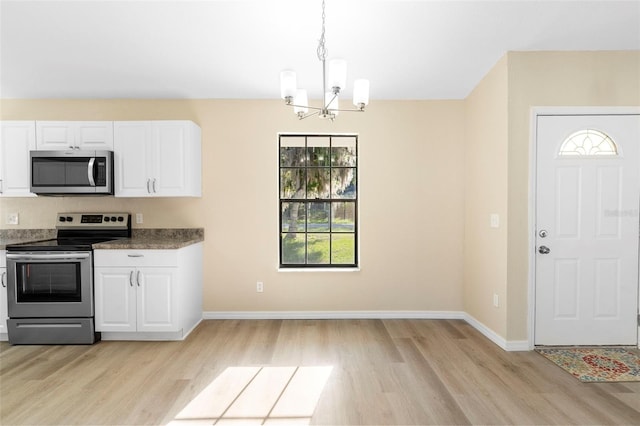 1550 Maxwell Ln, Deltona, FL 32738 - kitchen with stainless steel appliances, light wood finished floors, a chandelier, and white cabinets