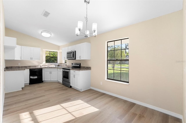 1550 Maxwell Ln, Deltona, FL 32738 - kitchen with stainless steel appliances, a chandelier, light wood-style flooring, white cabinets, and lofted ceiling