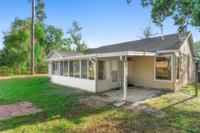 1550 Maxwell Ln, Deltona, FL 32738 - rear view of property featuring a sunroom, a patio area, a yard, stucco siding, and roof with shingles