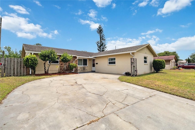 single story home featuring driveway and concrete block siding