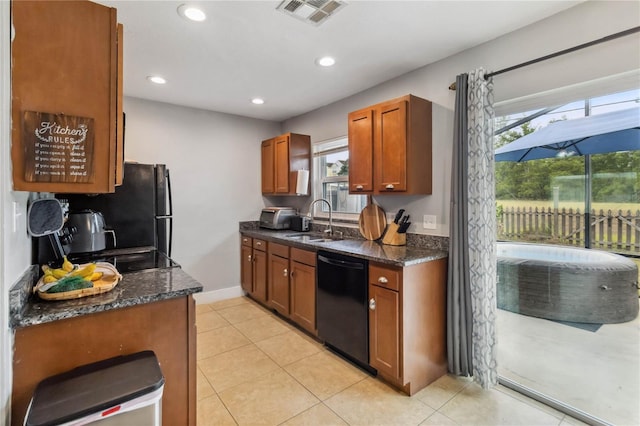 kitchen with black appliances, a sink, brown cabinets, dark stone counters, and recessed lighting