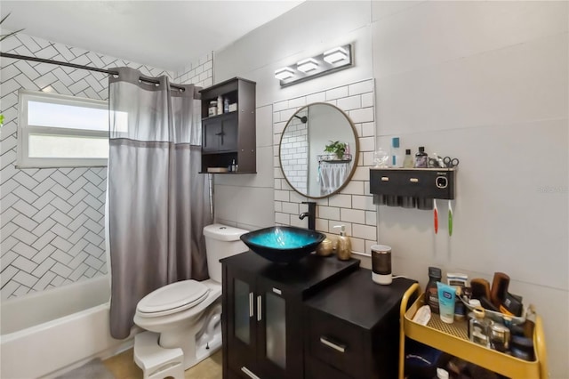 bathroom featuring toilet, shower / bath combo with shower curtain, vanity, and tile walls