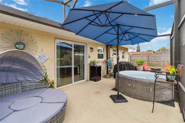 view of patio / terrace featuring a hot tub, fence, and grilling area