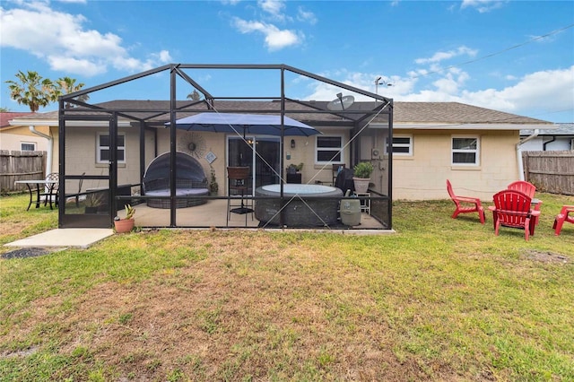 back of property with a patio, concrete block siding, and a lanai