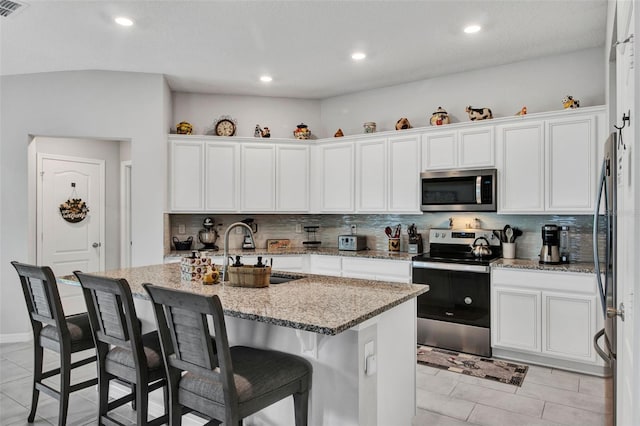208 Summerlin Ln, Haines City, FL 33844 - kitchen featuring stainless steel appliances, a sink, decorative backsplash, white cabinets, and recessed lighting