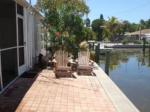 view of patio featuring a water view and a dock