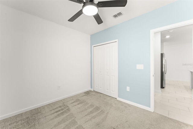 6834 Wilson Hammock Ave, Groveland, FL 34736 - unfurnished bedroom with freestanding refrigerator, a closet, carpet, baseboards, and ceiling fan