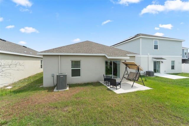 6834 Wilson Hammock Ave, Groveland, FL 34736 - back of house featuring central air condition unit, a shingled roof, a patio, stucco siding, and a lawn