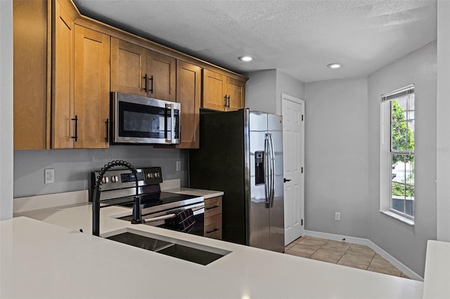 2498 Saint Augustine Blvd, Haines City, FL 33844 - kitchen with stainless steel appliances, light countertops, light tile patterned flooring, recessed lighting, and brown cabinets