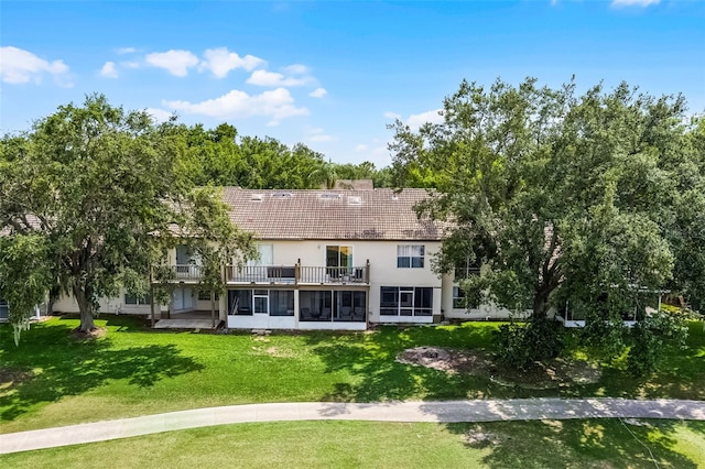 2498 Saint Augustine Blvd, Haines City, FL 33844 - back of property featuring a balcony, a sunroom, stucco siding, a yard, and a tile roof