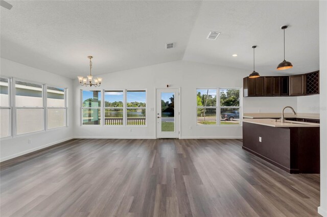 1040 20th St, Orlando, FL 32805 - unfurnished dining area featuring a chandelier, a sink, lofted ceiling, dark wood-type flooring, and baseboards