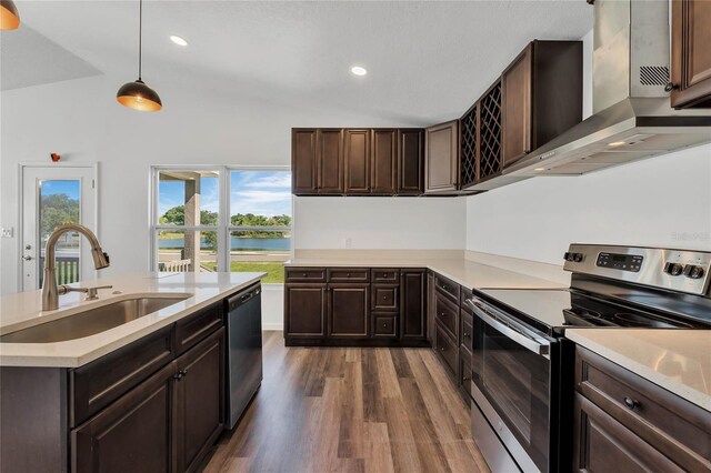 1040 20th St, Orlando, FL 32805 - kitchen with stainless steel appliances, a sink, dark wood-style floors, light countertops, and wall chimney range hood