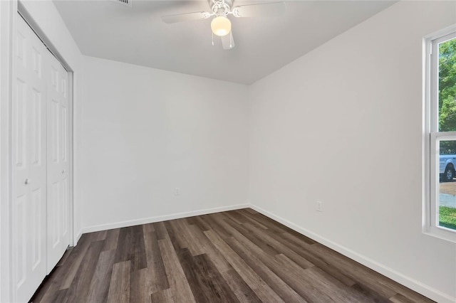 1040 20th St, Orlando, FL 32805 - unfurnished bedroom with dark wood-style flooring, a closet, baseboards, and a ceiling fan
