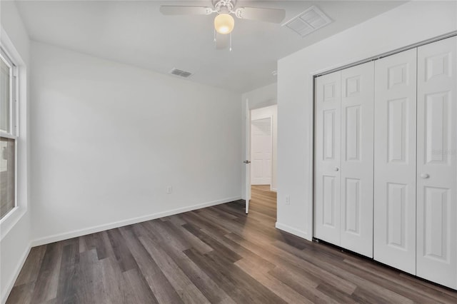 1040 20th St, Orlando, FL 32805 - unfurnished bedroom with dark wood finished floors, baseboards, a closet, and ceiling fan