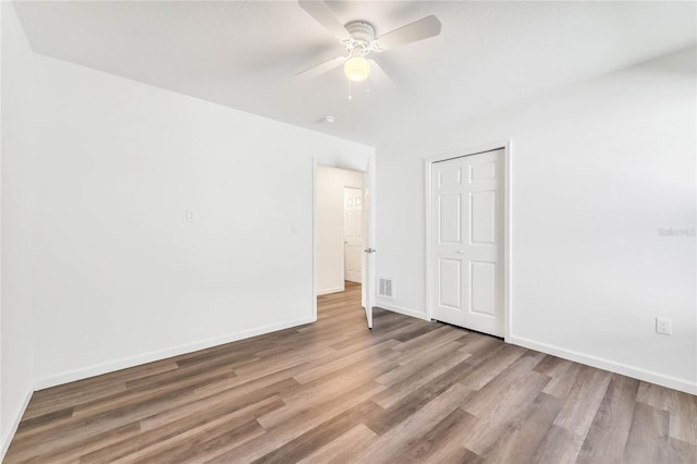 1040 20th St, Orlando, FL 32805 - unfurnished bedroom with wood finished floors, baseboards, a closet, and ceiling fan
