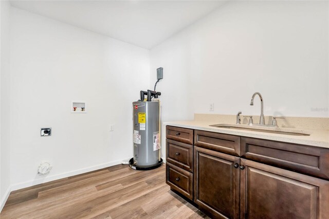 1040 20th St, Orlando, FL 32805 - laundry room featuring electric water heater, hookup for a washing machine, light wood finished floors, hookup for an electric dryer, and baseboards