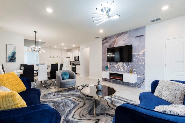 living room with a chandelier, a large fireplace, an accent wall, recessed lighting, and baseboards