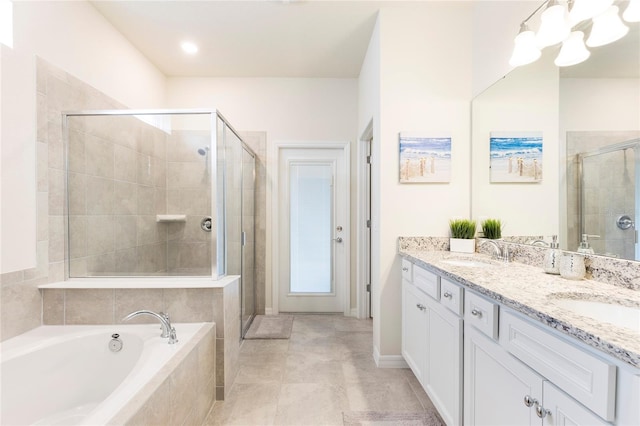 full bath with a shower stall, a chandelier, a bath, and double vanity