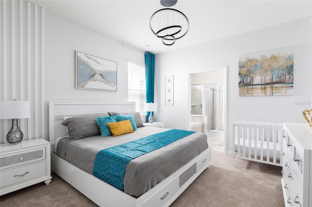 bedroom featuring carpet floors, a chandelier, baseboards, and ensuite bath