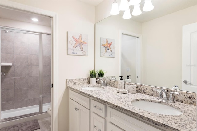 full bathroom with a stall shower, toilet, double vanity, a chandelier, and tile patterned floors
