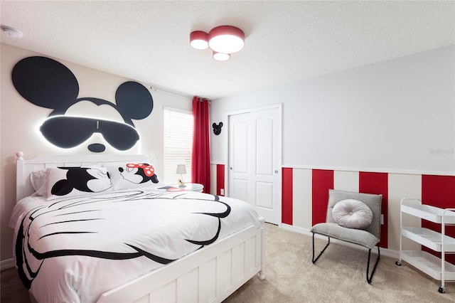 carpeted bedroom featuring baseboards and a closet