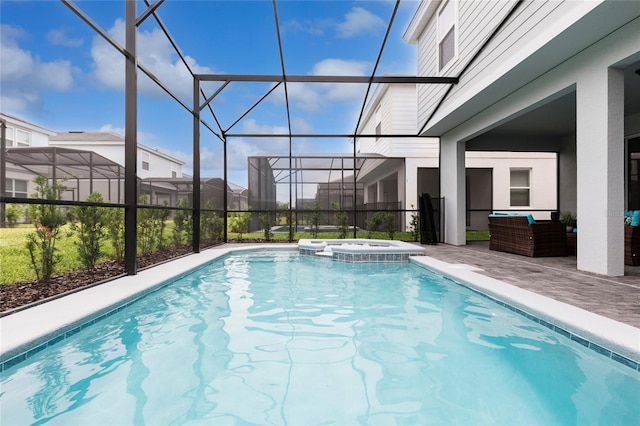 view of pool featuring a patio area, a pool with connected hot tub, an outdoor hangout area, and glass enclosure