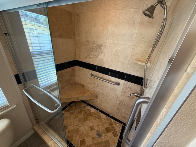 bathroom with a shower stall and toilet