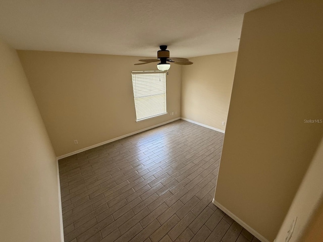 spare room featuring a ceiling fan and baseboards