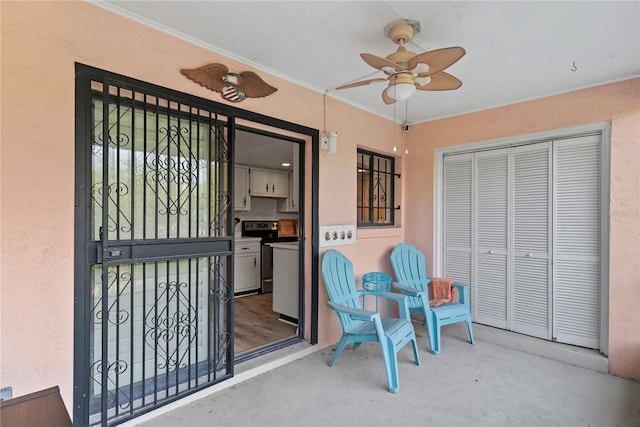 property entrance with a ceiling fan and stucco siding