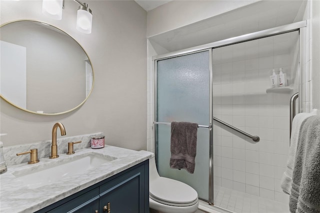 bathroom featuring toilet, a shower stall, and vanity