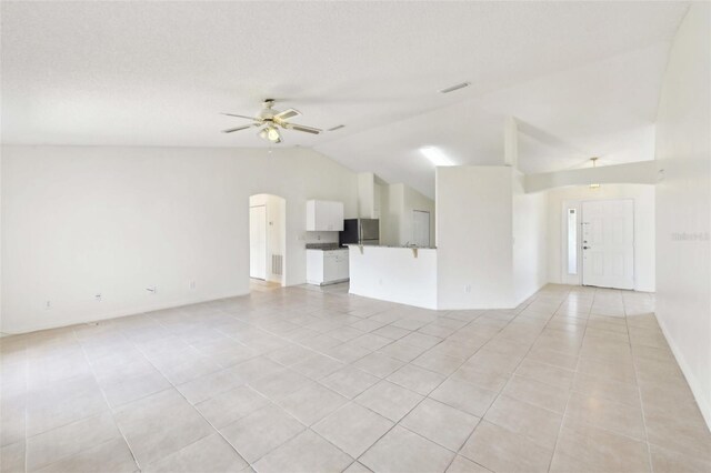 497 Lafayette St SW, Palm Bay, FL 32908 - unfurnished living room with light tile patterned floors, vaulted ceiling, ceiling fan, and arched walkways