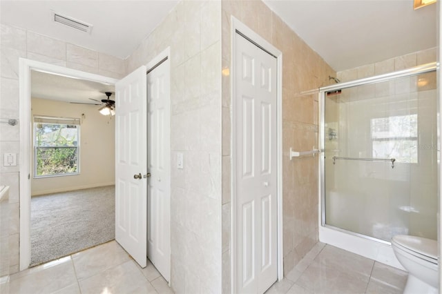 497 Lafayette St SW, Palm Bay, FL 32908 - full bathroom with tile patterned floors, a shower stall, tile walls, toilet, and a ceiling fan