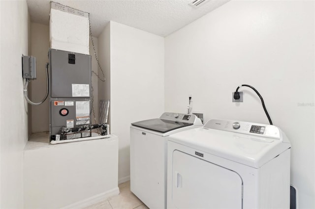497 Lafayette St SW, Palm Bay, FL 32908 - laundry area with independent washer and dryer, light tile patterned floors, a textured ceiling, and heating unit