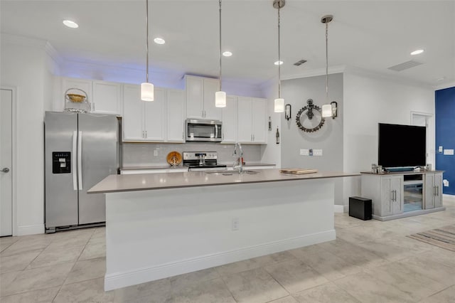 3149 Songbird Cir, Harmony, FL 34773 - kitchen with stainless steel appliances, crown molding, a sink, white cabinets, and a center island with sink