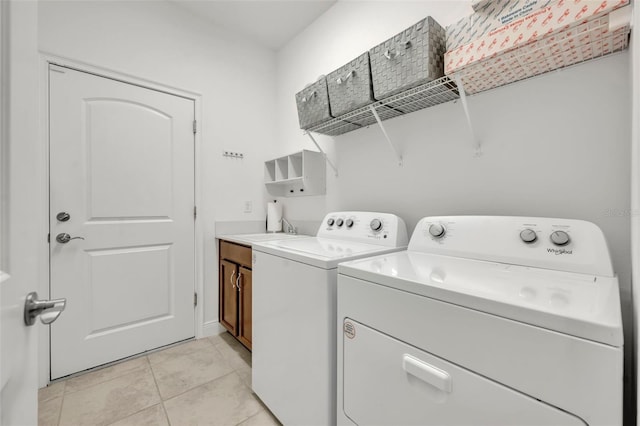 3149 Songbird Cir, Harmony, FL 34773 - laundry area featuring washer and clothes dryer, cabinet space, and light tile patterned flooring