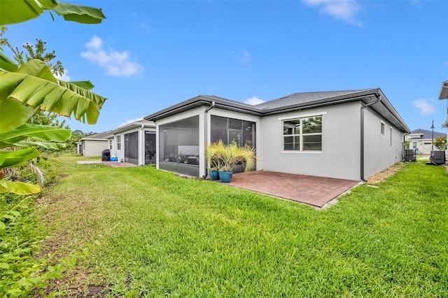 3149 Songbird Cir, Harmony, FL 34773 - rear view of property featuring a sunroom, a yard, a patio, and stucco siding