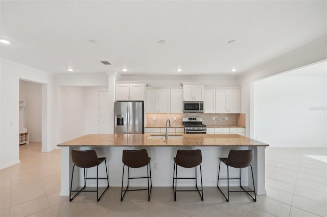 8932 SW 101st Cir, Ocala, FL 34481 - kitchen with stainless steel appliances, a sink, crown molding, a spacious island, and tasteful backsplash