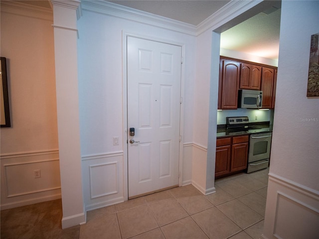 4816 Cayview Ave Unit 20111, Orlando, FL 32819 - kitchen with appliances with stainless steel finishes, dark countertops, crown molding, light tile patterned floors, and wainscoting