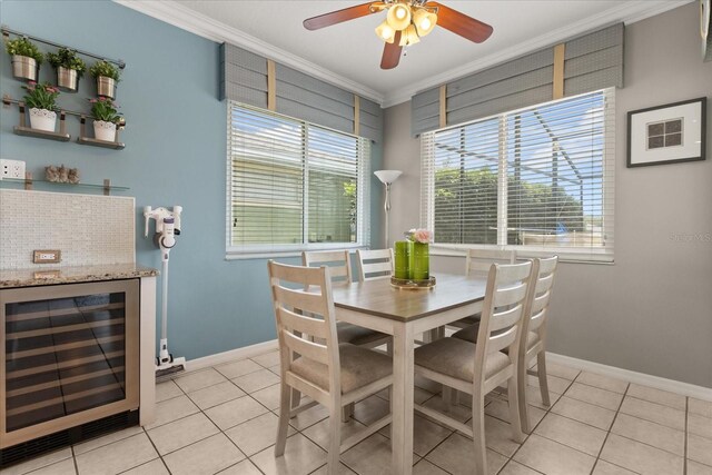 8522 Blue Horizon Ct, Kissimmee, FL 34747 - dining room featuring wine cooler, crown molding, light tile patterned flooring, baseboards, and ceiling fan