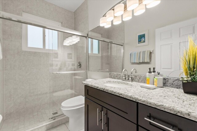 8522 Blue Horizon Ct, Kissimmee, FL 34747 - bathroom featuring toilet, vanity, a stall shower, and tile patterned flooring
