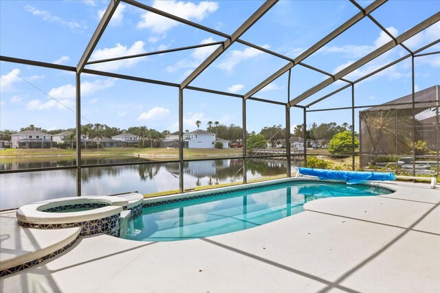 8522 Blue Horizon Ct, Kissimmee, FL 34747 - view of swimming pool with a water view, a pool with connected hot tub, a patio area, and glass enclosure