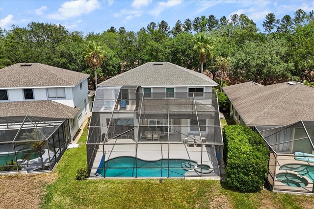 8522 Blue Horizon Ct, Kissimmee, FL 34747 - back of property featuring glass enclosure, a patio area, an outdoor pool, a lawn, and a jacuzzi