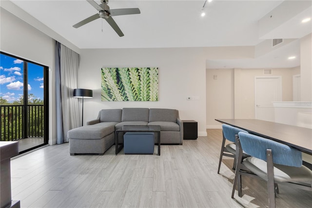 living area featuring light wood-style flooring and a ceiling fan