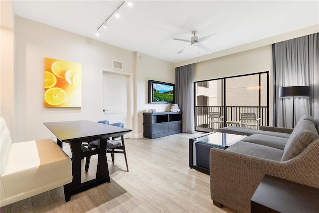 living area with a ceiling fan, light wood-style floors, track lighting, and baseboards
